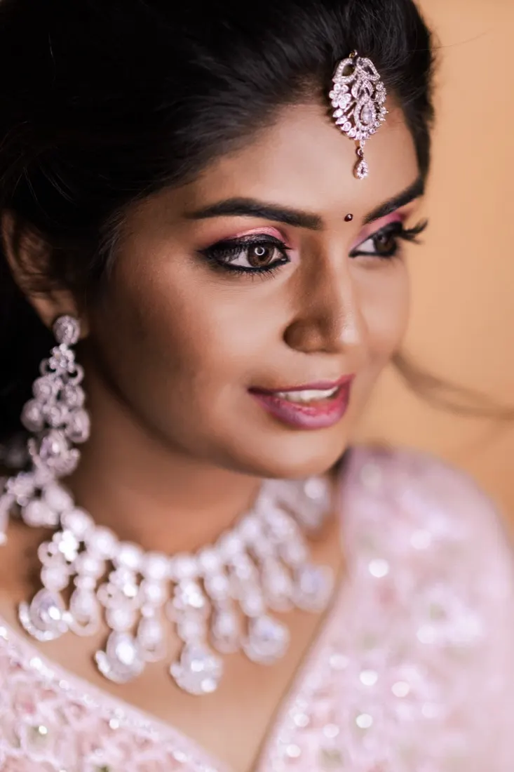 Close portrait of a bride with rose eyeshadow and a crystal maang tikka