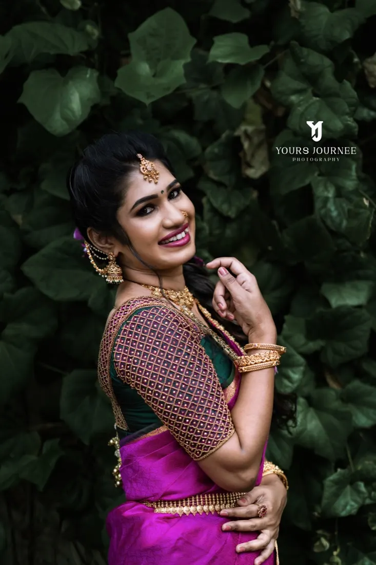 Bride laughing against dark leaves, jasmine and gold in her hair