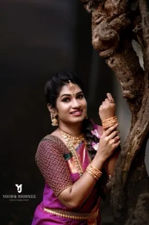 Bride leaning on a tree, bangles on both wrists
